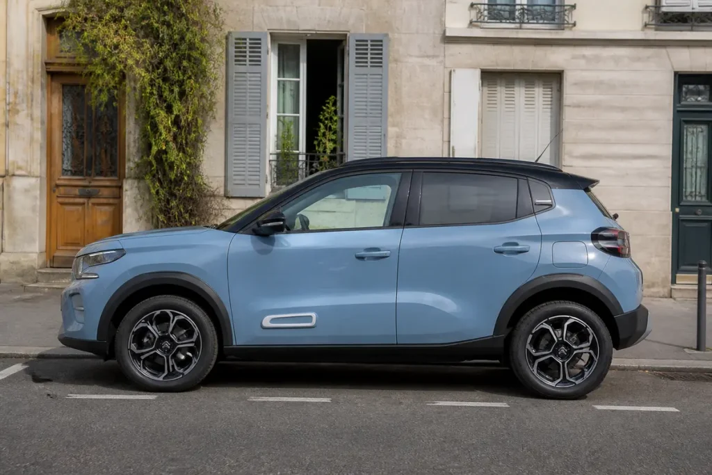 Citroën C3 neuve essence 5 portes stationnée devant maisons anciennes en ville.