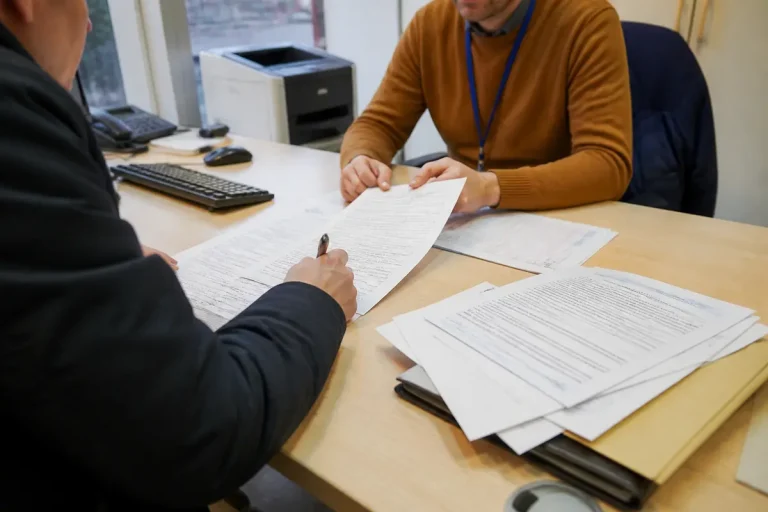 Deux hommes discutent de documents pour récupérer un permis après suspension