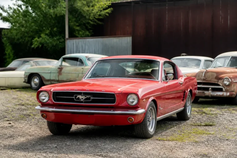 Voiture ancienne américaine rouge garée avec d'autres modèles classiques en arrière-plan