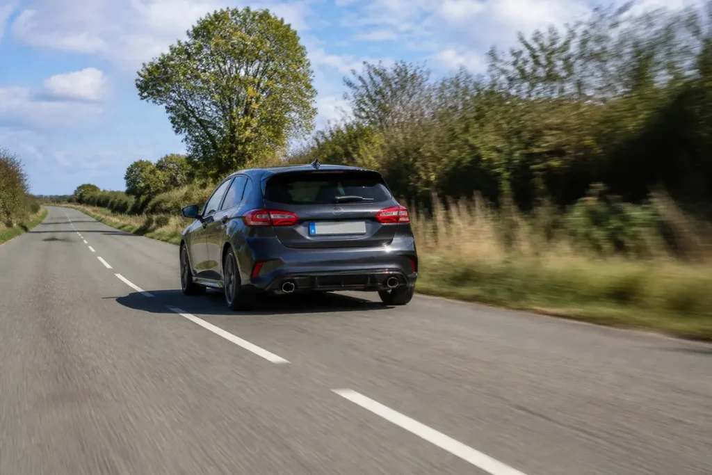 Voiture sur route de campagne, bruit notable durant la conduite sur bitume.