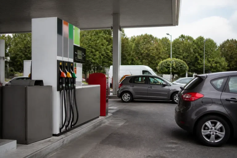 Station-service avec voitures, calcul du besoin moyen en litres d'essence pour 100 km