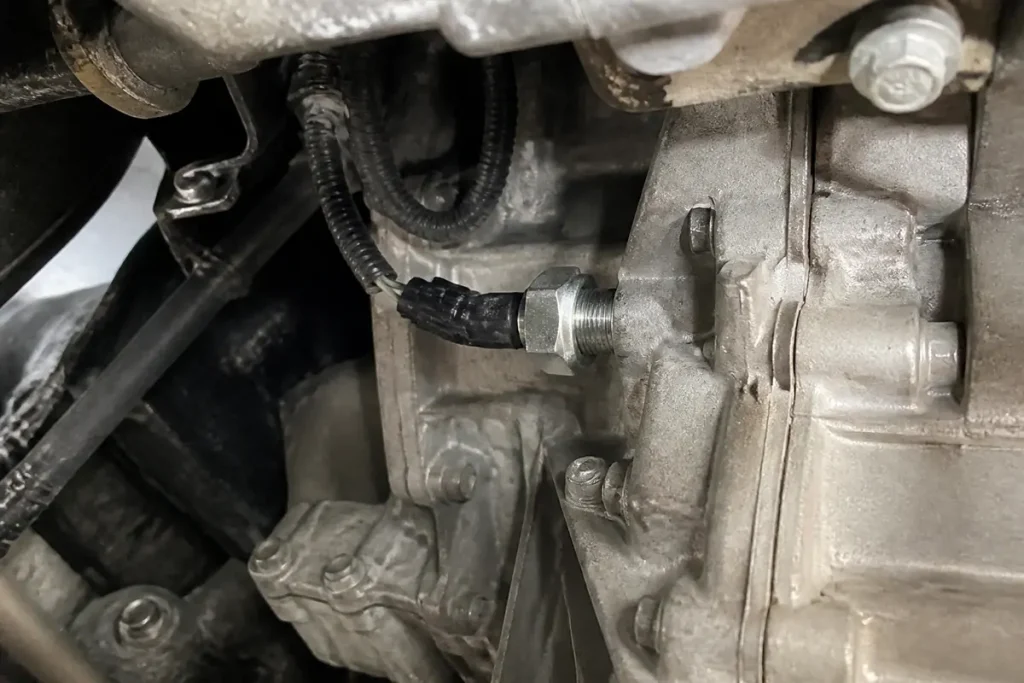 Contacteur de feux de recul fixé sur la boîte de vitesses d'une voiture